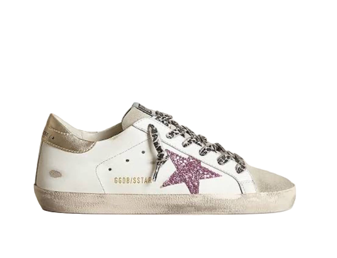 White sneaker with purple star and 'G' logo on a beige background
