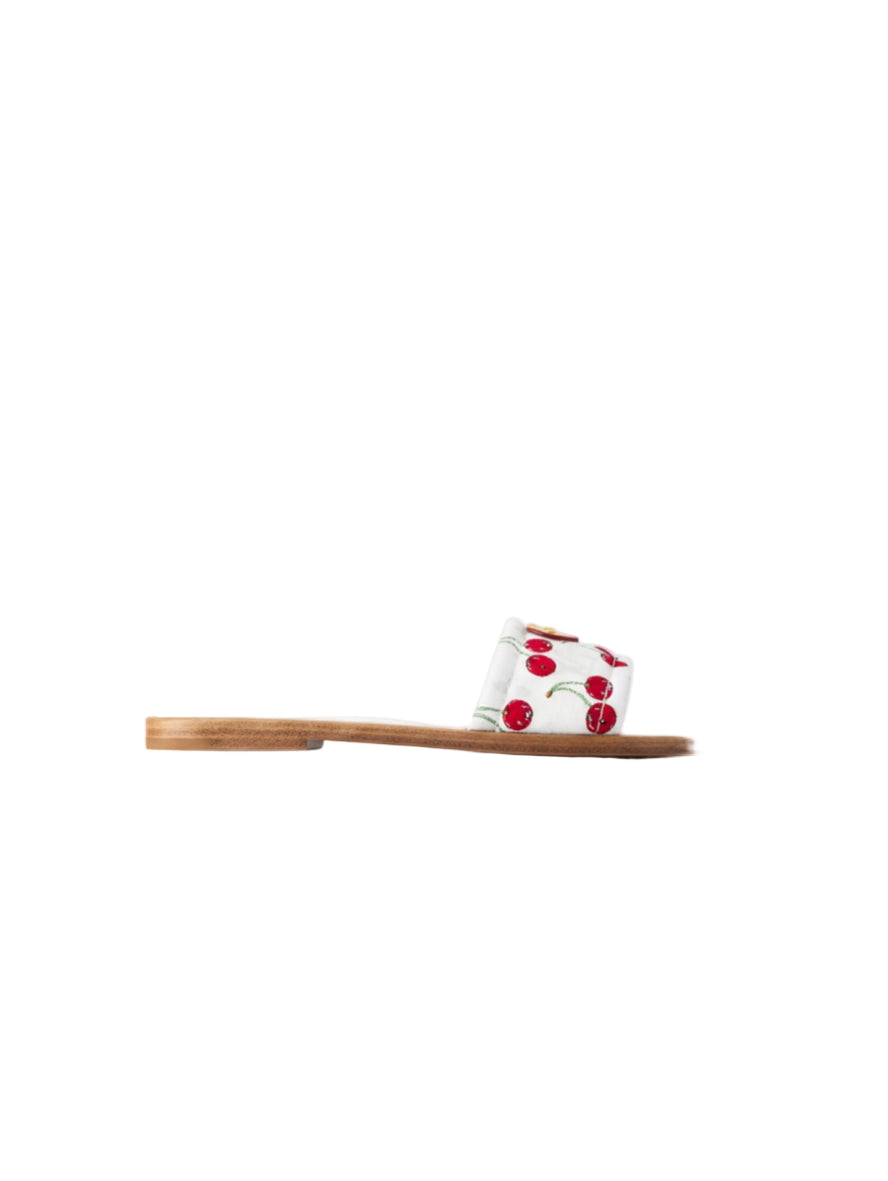 Small white container with red embellishments on a wooden tray against a white background
