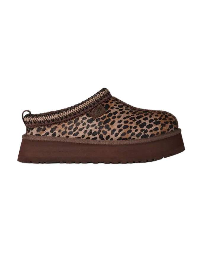 Leopard print slip-on shoe with brown sole on a white background
