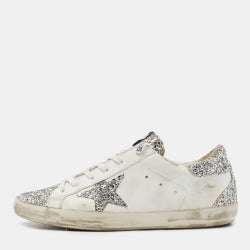 White sneaker with silver glittery details on a white background